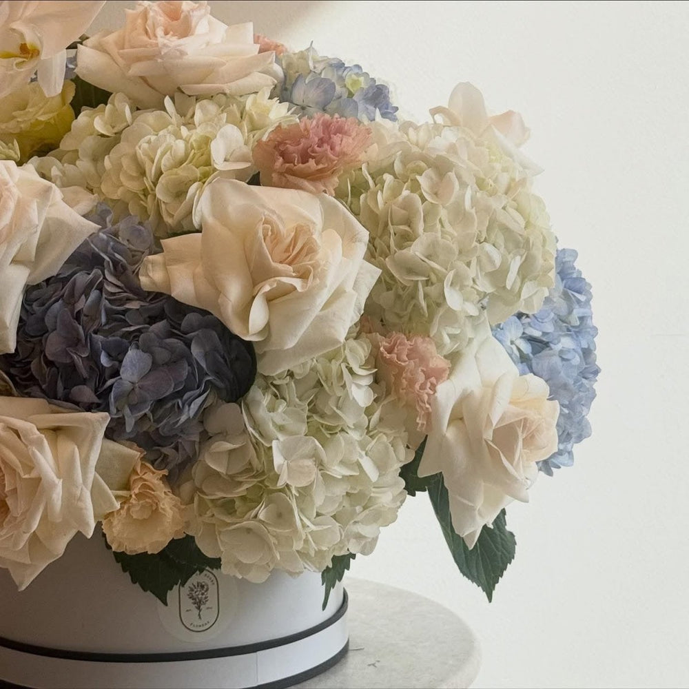 Luxury Floral Arrangement with White Roses, Hydrangeas, and Orchids in Elegant Hat Box - Rawadat Al Ward
