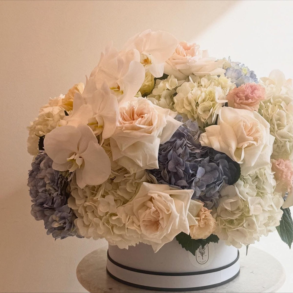 Luxury Floral Arrangement with White Roses, Hydrangeas, and Orchids in Elegant Hat Box - Rawadat Al Ward