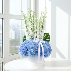 Elegant Blue Hydrangea and White Delphinium Flower Arrangement in White Hat Box
